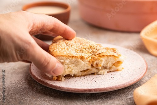 Apple Charlotte cake with hand on brown concrete, side view, close up, selective focus