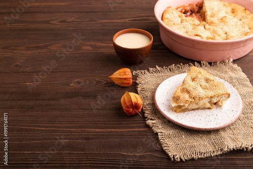 Apple Charlotte cake on brown wooden, side view copy space