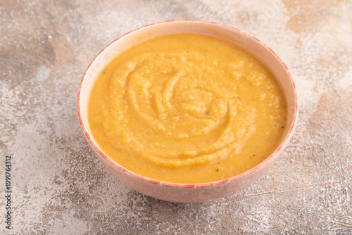 Pea cream soup, Puree, porridge in ceramic bowl on brown concrete, side view, close up