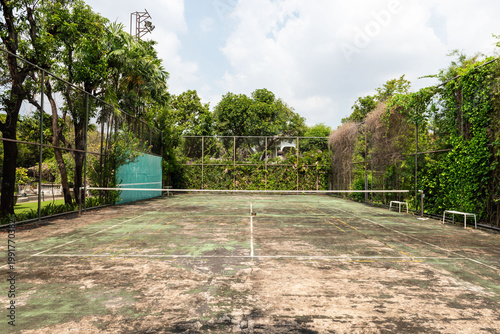 Foto Rustic tennis court amidst greenery.
