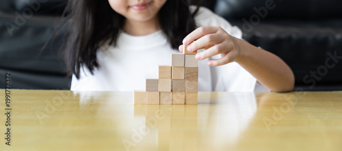фотографія Wooden blocks rising steps child behind patience effort planning strategy step progress focus control consistency logical development achievement