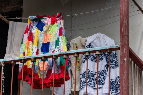 Traditional Panamanian pollera and a vibrant patchwork skirt hanging on a clothesline from a balcony in Casco viejo, Panama city, showcasing local culture and everyday life - stock photo