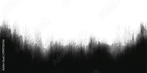 A black silhouette of grass stands against a misty black and white landscape of a foggy forest lake at sunrise during a cold winter morning