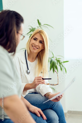 Smiling Female Doctor Consulting With Patient in Medical Clinic During Routine Health Appointment