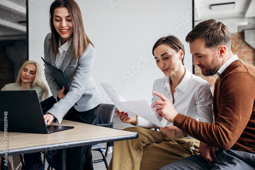 Fotografie Group of diverse business people engaging in a productive meeting, reviewing doc