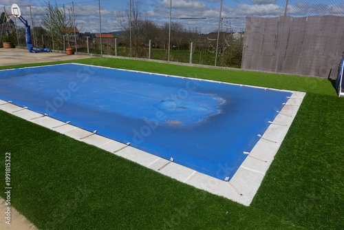 Swimming pool tarp protecting backyard residential area