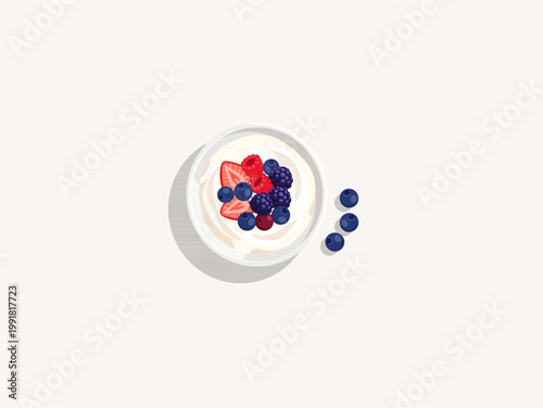 Top view of greek yogurt bowl topped with mixed berries and sliced strawberries with blueberries aside