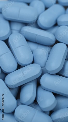 Heap of blue pills, rotation. Pharmaceutical Industry concept, zoom frame