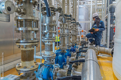 Male work inspection process valve control at the process area of the pipeline, flowing stainless steel chemicals in a factory