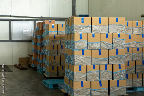 Packaged fruit products in cardboard boxes stacked on pallets in a clean storage facility or distribution center.