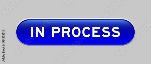 Blue color capsule shape button with word in process on gray background
