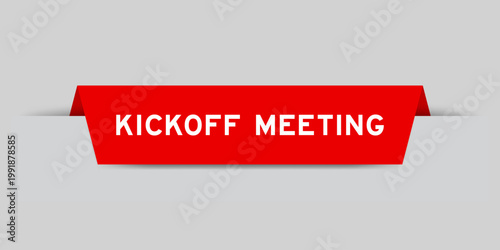 Red color inserted label with word kickoff meeting on gray background