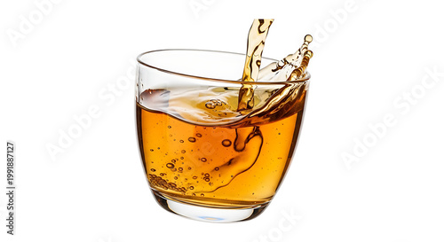 Amber liquid splashing into a clear glass, creating dynamic fluid motion and droplets, isolated on white