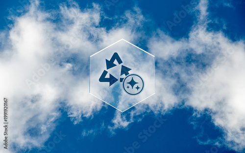 Conceptual image of an artificial intelligence recycling icon with sparkles inside a glass hexagon floating against a blue cloudy sky representing sustainable tech innovation