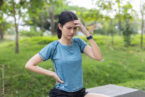 Konstfotografi women feeling headache and lower back pain after outdoor workout in park