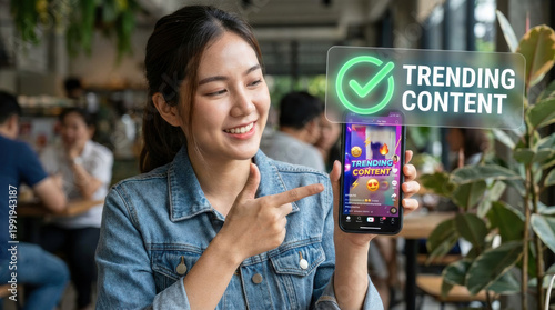 Young woman smartphone social media trending content live stream influencer cafe smile emoji Young woman holding smartphone with social media trending content screen cafe, smiling confidently