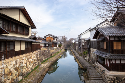 Canal lined with traditional houses in the historic district of Omihachiman, Japan, peaceful scene of classic Japanese architecture.