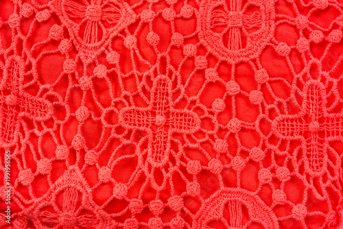 Red lace fabric texture intricate floral pattern decorative textile background close up