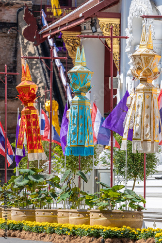 Fotografia Vibrant traditional Lanna lanterns, flags, and lotus plants adorn the ancient Wat Chedi Luang temple grounds in Chiang Mai, Thailand