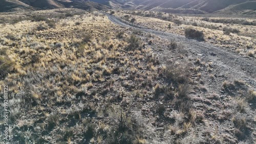 Aerial drone view of dry mountain landscape in San Juan Argentina under clear blue sky