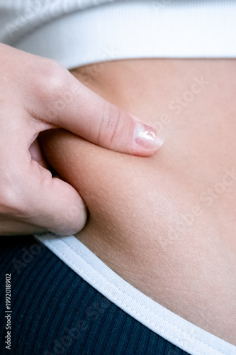 Woman overweight body. Female touching stomach near mirror. Weig