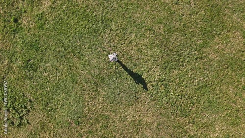 Aerial drone descending from top toward down to pilot with swirl rotation. camera performs a dynamic spiraling maneuver while approaching the ground from high altitude. Rotating perspective captures