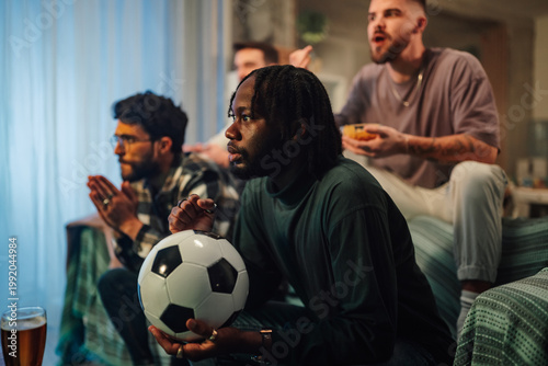 Quadro em tela Diverse men watching live soccer game at home, feeling excitement and anticipati