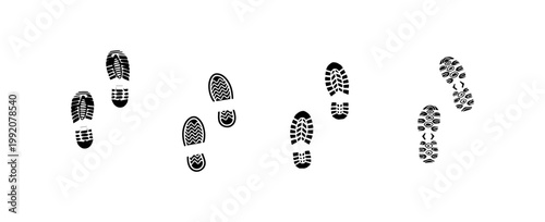 A trail of various footprints leads through a neutral area outdoors.