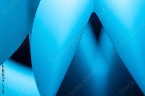 Blue paper curves creating abstract geometric patterns