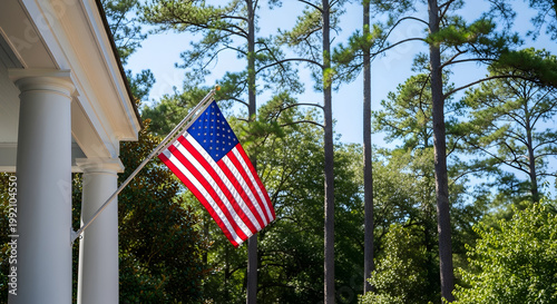 An American flag waving in the wind outside a house with columns on transparent background