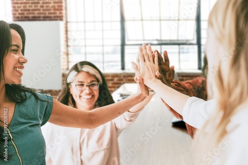 Foto Businesswomen putting hands in the middle