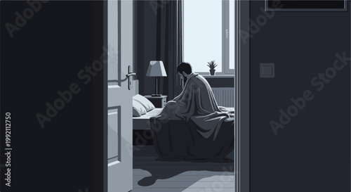 A solitary person sits on a bed, draped in a blanket, in a dimly lit room