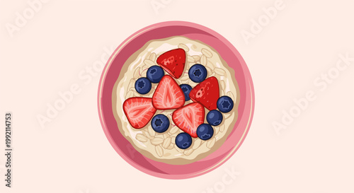 A pink bowl filled with oatmeal, topped with sliced strawberries and blueberries