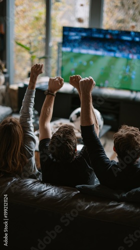 Group of friends cheering while watching a soccer match on TV