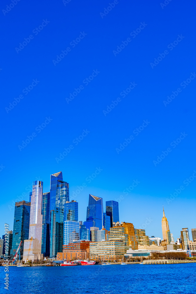 Fototapeta premium Hudson Yards shines against a clear blue sky in the Manhattan skyline