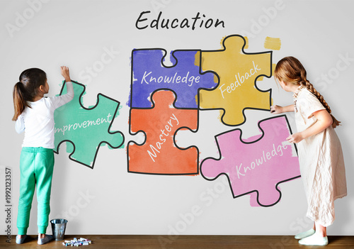Photos Children assembling puzzle pieces labeled with education concepts on a wall