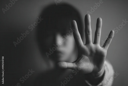 Blurry person showing stop hand gesture in monochrome close-up