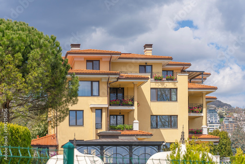 Φωτογραφία Picturesque Mediterranean-style apartment building with yellow facade, tiled roo
