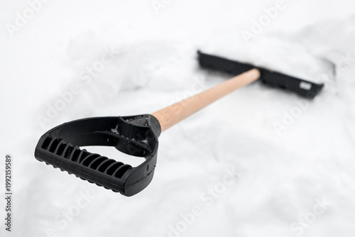 Snow shovel stuck upright in snowdrift, waiting for use