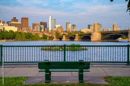 Empty park bench overlooking the Charles River with view of Longfellow Bridge and downtown Boston skyline in Massachusetts, USA