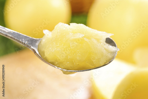 Quadro su tela Fresh Yellow Apple Sauce on Spoon with Whole Apples - Homemade Fruit Puree