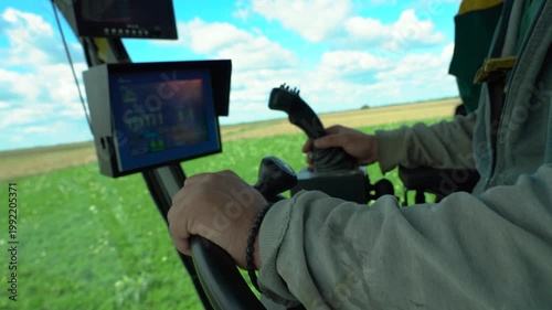 Farmer Hands Operating Carrot Harvester with Joystick and Steering Wheel in Slow Motion. Interior close-up of a modern harvester cabin during carrot harvest. The advancement of smart farming.