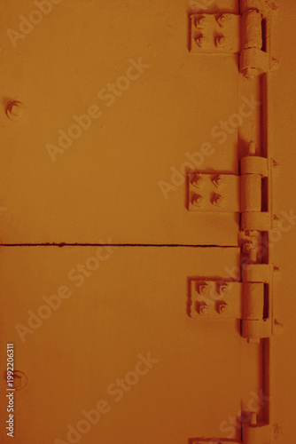 Orange-toned metal door with heavy hinges