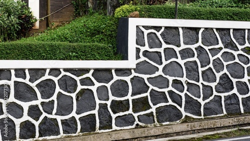 Slika na platnu A sturdy stone masonry embankment wall with a distinctive white-jointed pattern providing slope protection