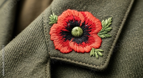 A close-up view of a red poppy embroidered on a green military jacket sleeve on Memoriam Day.