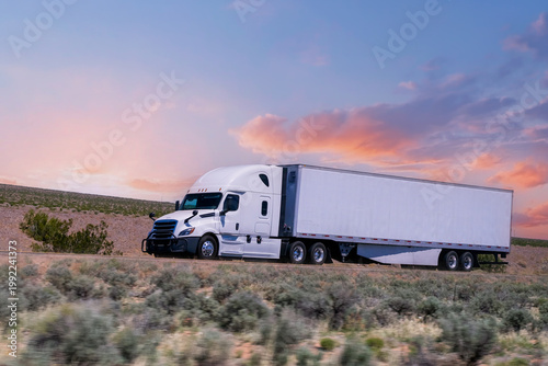 Truck driving on highway through nature and mountains. Commercial vehicle transport for logistics and shipping.
