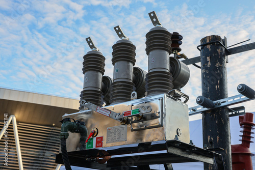 Three electrical transformers are on top of a pole