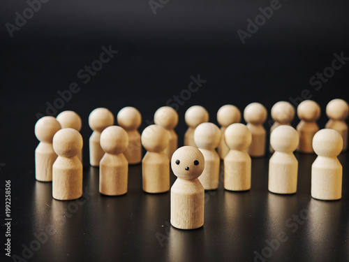 Wooden figures express individuality and stand alone against group pressures in a simple setup