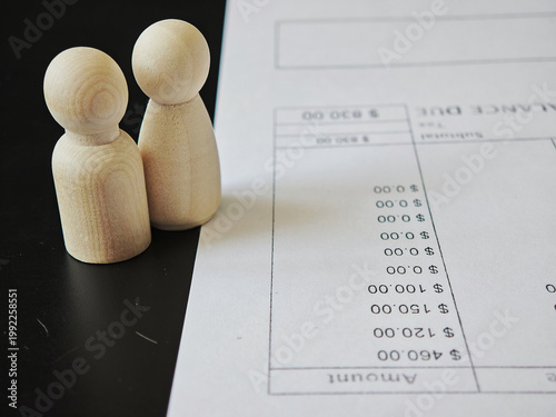 People plan finances with wooden figures and a budget sheet during a money management session at a table in a home office