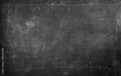 Matte black textured surface with fine scuff marks and white grain. Blackboard texture background